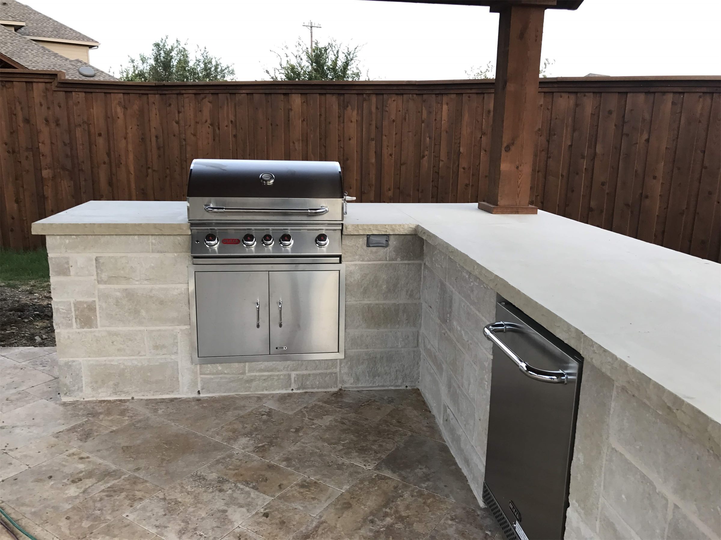 Stone outdoor kitchen under a covered patio